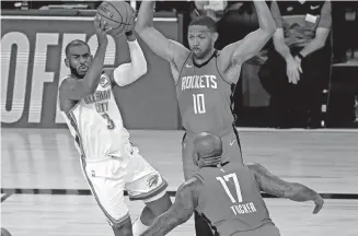  ??  ?? Thunder guard Chris Paul (3) passes the ball away from Rockets guard Eric Gordon (10) and forward P.J. Tucker (17) during the first quarter of Game 2 on Thursday. [KEVIN C. COX/POOL PHOTO VIA AP]