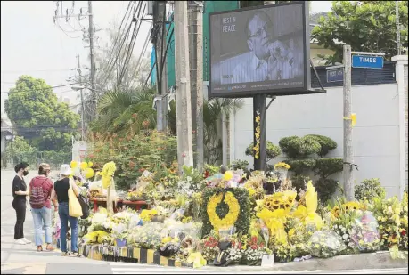  ?? MICHAEL VARCAS ?? People offer flowers near the Aquino family residence on Times Street in Quezon City as they pay tribute yesterday, a day after the burial of former president Benigno Aquino III.