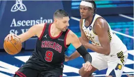  ?? MICHAEL CONROY / AP ?? Chicago Bulls center Nikola Vucevic (9) drives on Indiana Pacers center Myles Turner on Tuesday. Vucevic had 32 points, 17 rebounds and 5 assists.