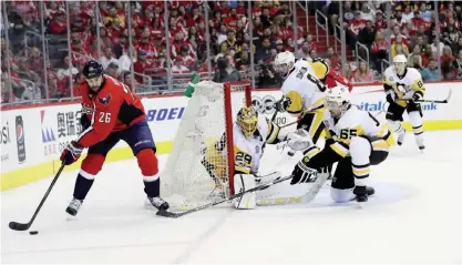  ??  ?? WASHINGTON DC: Marc-Andre Fleury #29 and Ron Hainsey #65 of the Pittsburgh Penguins guard the net as Daniel Winnik #26 of the Washington Capitals moves the puck in Game Two of the Eastern Conference Second Round during the 2017 NHL Stanley Cup Playoffs...