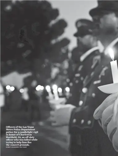  ?? ROBERT HANASHIRO, USA TODAY ?? Officers of the Las Vegas Metro Police Department gather for a candleligh­t vigil in honor of Charleston Hartfield, 34, an off-duty officer who was killed while trying to help fans flee the concert grounds.