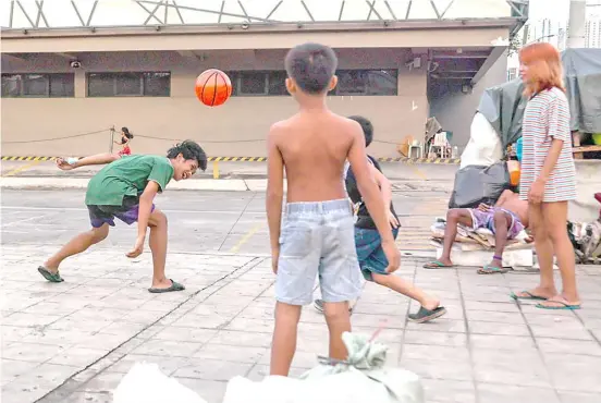  ?? PHOTOGRAPH BY RIO DELUVIO FOR THE DAILY TRIBUNE @tribunephl_rio ?? KIDS play volleyball using a toy basketball along the boundary of Manila and Makati, making it their afternoon leisure.