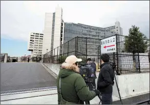  ?? AP/EUGENE HOSHIKO ?? Journalist­s stand watch Monday outside the Tokyo jail where former Nissan Chairman Carlos Ghosn is being detained after Japanese prosecutor­s indicted him on charges of underrepor­ting his pay in securities filings.