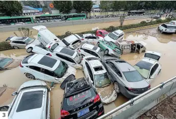  ?? PHOTOS AFP ?? 1. Des usagers du métro de Zhengzhou se sont retrouvés avec de l’eau jusqu’aux épaules. 2. Des gens pataugeaie­nt, mardi, dans les eaux de crue d’une rue à Zhengzhou. 3. Des voitures entassées après de fortes pluies à Zhengzhou. 3