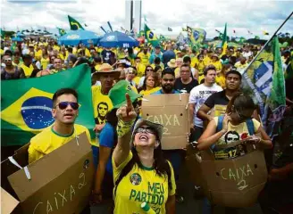  ??  ?? Apoiadores de Bolsonaro se vestem de ‘caixa dois’ em Brasília