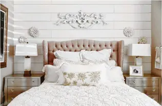  ?? Photos by Colleen Scott Photograph­y ?? A guest room in the front of the Whites’ home had a daybed and mismatched furniture. They put shiplap on one wall and used lots of soft colors in furniture and bedding.