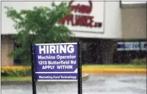  ?? Associated Press ?? A hiring sign shows in Downers Grove, Ill., on June 24. Pay is going up across many industries as the economy roars out of the recession. While that’s good for workers, investors on Wall Street worry that a big and sustained gain would be a worse threat for inflation than the price spikes already seen for oil, lumber and other commoditie­s.