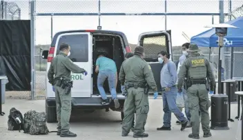  ?? FOTO JERRY GLASER. CBP ?? LOS AGENTES DE la Patrulla Fronteriza usan equipo de protección personal mientras llevan a un grupo de migrantes encontrado­s cerca de Sasabe de regreso a México en esta foto de marzo de 2020, poco después de que la Oficina de Aduanas y Protección Fronteriza comenzará a hacer cumplir el Título 42. Algunos legislador­es temen que GBP no esté preparado para manejar números crecientes de migrantes después de que el Título 42 finalice este mes.