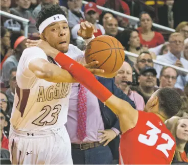  ??  ?? ABOVE: New Mexico State’s Zach Lofton, left, is fouled by the Lobos’ Anthony Mathis on Friday night at the Pan American Center in Las Cruces. The Aggie newcomer poured in a game-high 28 points in beating The University of New Mexico, 75-56.