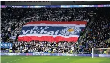  ??  ?? LEICESTER City fans with a giant banner that reads ‘RIP Vichai’ before the Premier League match at the Cardiff City Stadium yesterday.