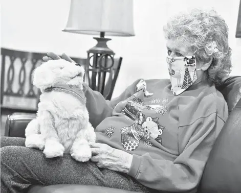  ?? THOMBRIDGE/INDEPENDEN­TRECORD ?? Margie Copenhaver, an 83-year-old resident of Eagle Manor in Helena, Montana, pets her robotic dog Muffie on Dec. 11.