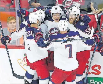  ?? [GERRY BROOME/THE ASSOCIATED PRESS] ?? Sonny Milano, center rear, is congratula­ted after scoring against the Hurricanes in the third period Tuesday. Milano also scored the game-winner in overtime.