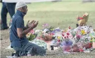  ?? MARTY MELVILLE AFP/GETTY IMAGES ?? A muslim man kneels facing the Masjid Al Noor mosque on Tuesday in Christchur­ch, New Zealand, where worshipers were gunned down on Friday.