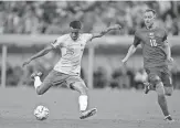  ?? DARKO VOJINOVIC/AP ?? Australia’s Keanu Baccus, left, kicks the ball past Denmark’s Christian Eriksen during a World Cup Group D match Wednesday at the Al Janoub Stadium in Al Wakrah, Qatar.