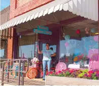  ?? Staff photo by Neil Abeles ?? ■ Carla Surratt waves from her flower and gift shop in Linden, Texas. Even though it’s difficult to get the fresh flowers people want and need, she’s been able to fill orders in some manner for every request.