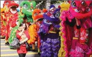  ?? @HKC__ / INSTAGRAM ?? A woman holds her dog dearly at the lion dance parade in Tsim Sha Tsui.