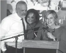  ?? ADOLPHE PIERRE-LOUIS/JOURNAL ?? New Mexico True Heroes honoree Clay Schroff, left, is hugged by Gov. Susana Martinez, while wife Michelle Schroff speaks at the podium during a ceremony earlier this week to honor five New Mexicans devoted to making the state a better place to live....