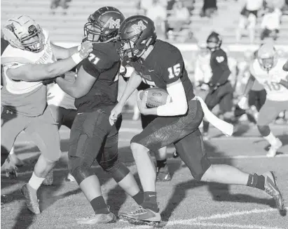  ?? KARL MERTON FERRON/BALTIMORE SUN ?? McDonogh quarterbac­k Preston Howard cuts behind offensive lineman Antonio Tripp during aa touchdown run on Friday night.