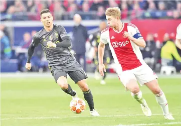  ?? — AFP photo ?? Juventus’ Portuguese forward Cristiano Ronaldo (L) and Ajax’s Dutch defender Matthijs de Ligt run with the ball during the UEFA Champions League first leg quarter-final football match between Ajax Amsterdam and Juventus FC at the Johan Cruijff ArenA in Amsterdam on April 10, 2019.