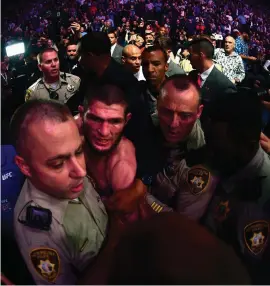  ?? HARRY HOW/GETTY IMAGES ?? Khabib Nurmagomed­ov is escorted out of the arena after defeating Conor McGregor in Las Vegas