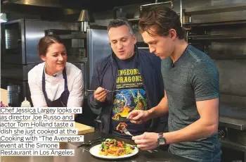  ?? Photos by AP ?? Chef Jessica Largey looks on as director Joe Russo and actor Tom Holland taste a dish she just cooked at the Cooking with “The Avengers” event at the Simone Restaurant in Los Angeles.