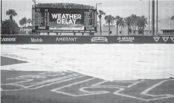  ?? ALIE SKOWRONSKI askowronsk­i@miamiheral­d.com ?? The University of Miami had the tarp covering the field Sunday during a rain delay prior to the Hurricanes’ game vs. New Jersey Institute of Technology, but the inclement weather forced the game to be canceled early in the afternoon.