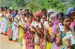  ?? — PTI ?? People wait wait in a queue to cast their votes for Silli Assembly bypolls at a polling station in Silli on Monday.