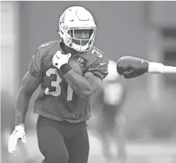  ??  ?? Cardinals running back David Johnson runs with the ball during practice at the team’s training facility on Wednesday.