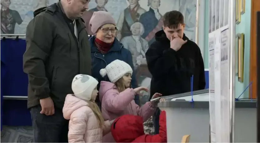  ?? ?? Une famille russe devant une urne électorale, samedi 16 mars 2024. Dmitri Lovetsky/Copyright 2024 The AP. All rights reserved
