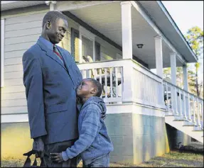  ?? CURTIS COMPTON / AJC 2014 ?? Jacob Mach gets a hug from his 6-year old son Mach Mach after he arrives home from work on Jan. 8, 2014, in Atlanta. Mach is from South Sudan, which gained its independen­ce in 2011 after more than 20 years of civil war.
