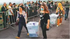  ?? AFP ?? Lebanese civil servants assigned to run polling stations carry ballot boxes in Beirut yesterday.