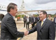  ??  ?? El presidente de Brasil, Jair Bolsonaro (izq.), saluda al vicepresid­ente Hamilton Mourao, el miércoles al llegar a Brasilia, tras ser dado de alta.