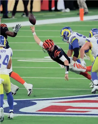  ?? GETTY IMAGES ?? Joe Burrow throws a desperatio­n pass while pressured by the Rams’ Aaron Donald. The pass landed incomplete, ending the Bengals’ hopes.