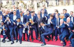  ?? AFP ?? France players and their coach Didier Deschamps (third right) celebrate winning the World Cup with French president Emmanuel (centre) at the Elysee Palace on Monday in Paris.