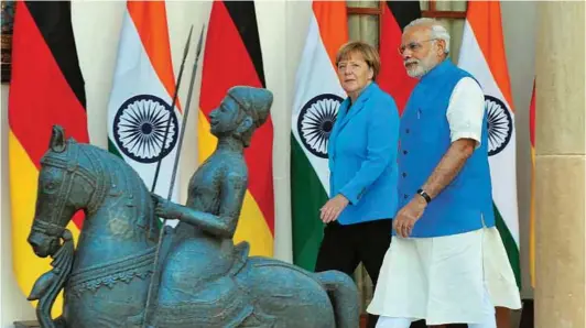  ?? PHOTOGRAPH­S: PIB ?? (Above) Prime Minister Narendra Modi with the German Chancellor Dr Angela Merkel at Hyderabad House in New Delhi. (Left) German Chancellor Merkel introducin­g Prime Minister Modi to the German delegation at the ceremonial reception at Rashtrapat­i Bhavan...