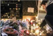  ?? JEAN FRANCOIS BADIAS — THE ASSOCIATED PRESS ?? A man lights a candle as he pays respects to the victims the night following an attack that killed three persons and wounded at least 13, in Strasbourg, eastern France, Wednesday.