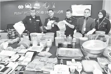  ??  ?? Amran (left) showing the seized items during a press conference at the Selangor police headquarte­rs. — Bernama photo