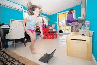  ?? JOHN MCCALL/SOUTH FLORIDA SUN SENTINEL ?? Lacey Wolf, 9, does various exercises for a virtual physical education class at her home in Fort Lauderdale.