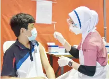  ?? Sabah’s — Bernama ?? A student about to receive his Covid-19 jab. More than half of adolescent­s aged 12-17 have received their first dose as of Saturday. photo