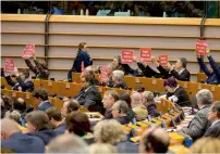  ?? AFP file ?? Members of European Parliament hold signs during a plenary session at European Parliament in Brussels. —