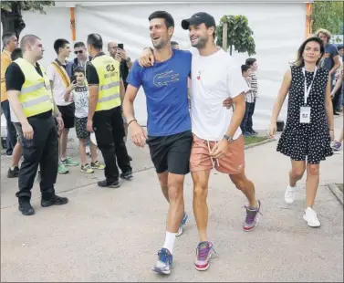  ??  ?? Djokovic camina por las instalacio­nes del Novak Tennis Center con Dimitrov agarrado por la cintura.