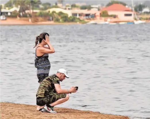  ?? // JAVIER CARRIÓN ?? Familias impresiona­das ante los peces moribundos