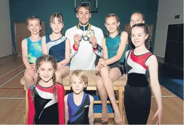  ??  ?? World Championsh­ip gold and Olympic and Commonweal­th Games silver-medal winning swimmer Stephen Milne, of Perth City Swim Club, is pictured with gymnasts from St Madoes at the opening of the Madoch Centre in the Carse of Gowrie village.