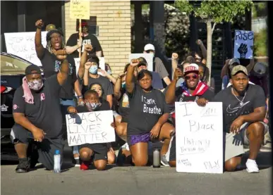  ?? STAFF PHOTOS BY TROY STOLT ?? Demonstrat­ors take a knee on Hamilton Street during protests Saturday over Dalton’s statue of Confederat­e Gen. Joseph E. Johnston in Dalton, Ga.