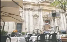  ?? (AP/Gregorio Borgia) ?? A waiter sets a table in an outdoor space of a restaurant in Rome.