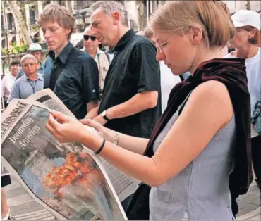  ?? / JOAN GUERRERO ?? Lectores con diarios nacionales e internacio­nales en La Rambla de Barcelona, el 12 de septiembre de 2001, al siguiente día del ataque terrorista contra EE UU.