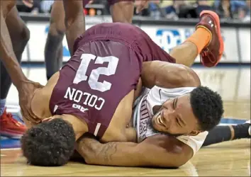  ?? Matt Freed/Post-Gazette photos ?? Marcus Weathers, right, wrestles for possession of the ball with Fordham’s Josh Colon Wednesday night in the second half of their Atlantic 10 Conference game. Duquesne defeated Fordham, 58-56, in overtime at PPG Paints Arena.