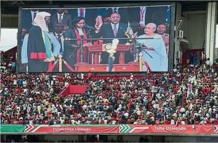  ?? — AFP ?? End of crisis?: Kenyatta appearing on a giant screen as he takes the oath of office during his inaugurati­on ceremony at Kasarani Stadium in Nairobi.