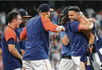  ??  ?? Astros players and coaching staff embrace Altuve after he scored Sunday at Minute Maid Park. Altuve finished 1 for 5, with the three-run homer being his only hit, and had three RBIs.