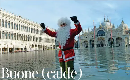  ??  ?? Acqua alta Un «Babbo Natale» con gli stivaloni attraversa piazza San Marco a Venezia dove ieri la marea ha raggiunto un’altezza di 144 centimetri senza causare disagi gravi all’attività giornalier­a della città (Epa)